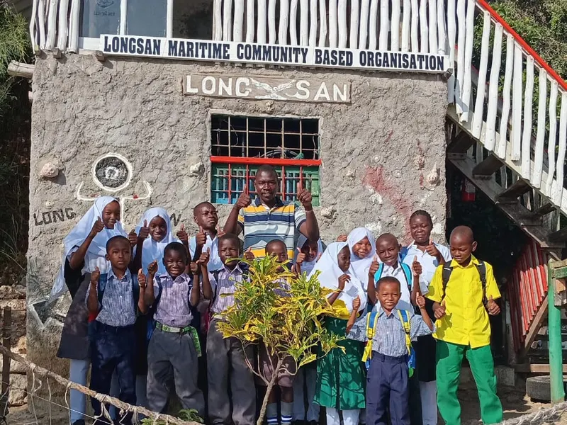 School children giving thumbs up in front of the LongSan Maritime building