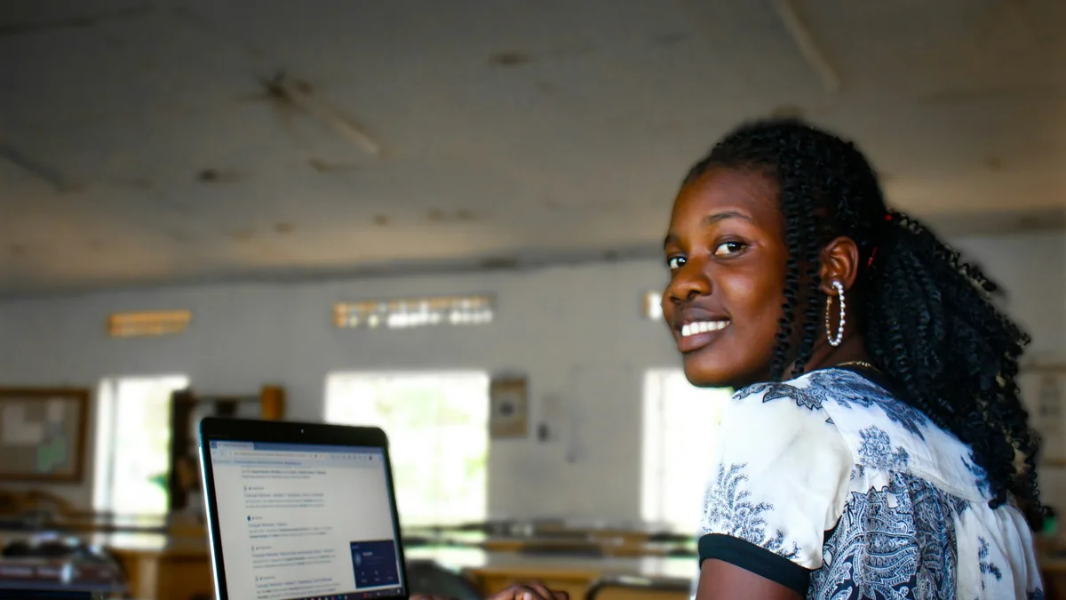 A young woman working on a laptop in a classroom